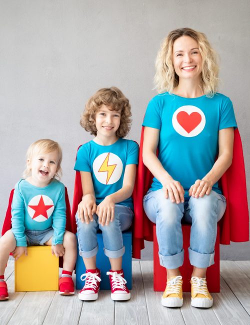 Family of superheroes playing at home. Mother, daughter and son having fun together. Parents with children pretend to be a super heroes